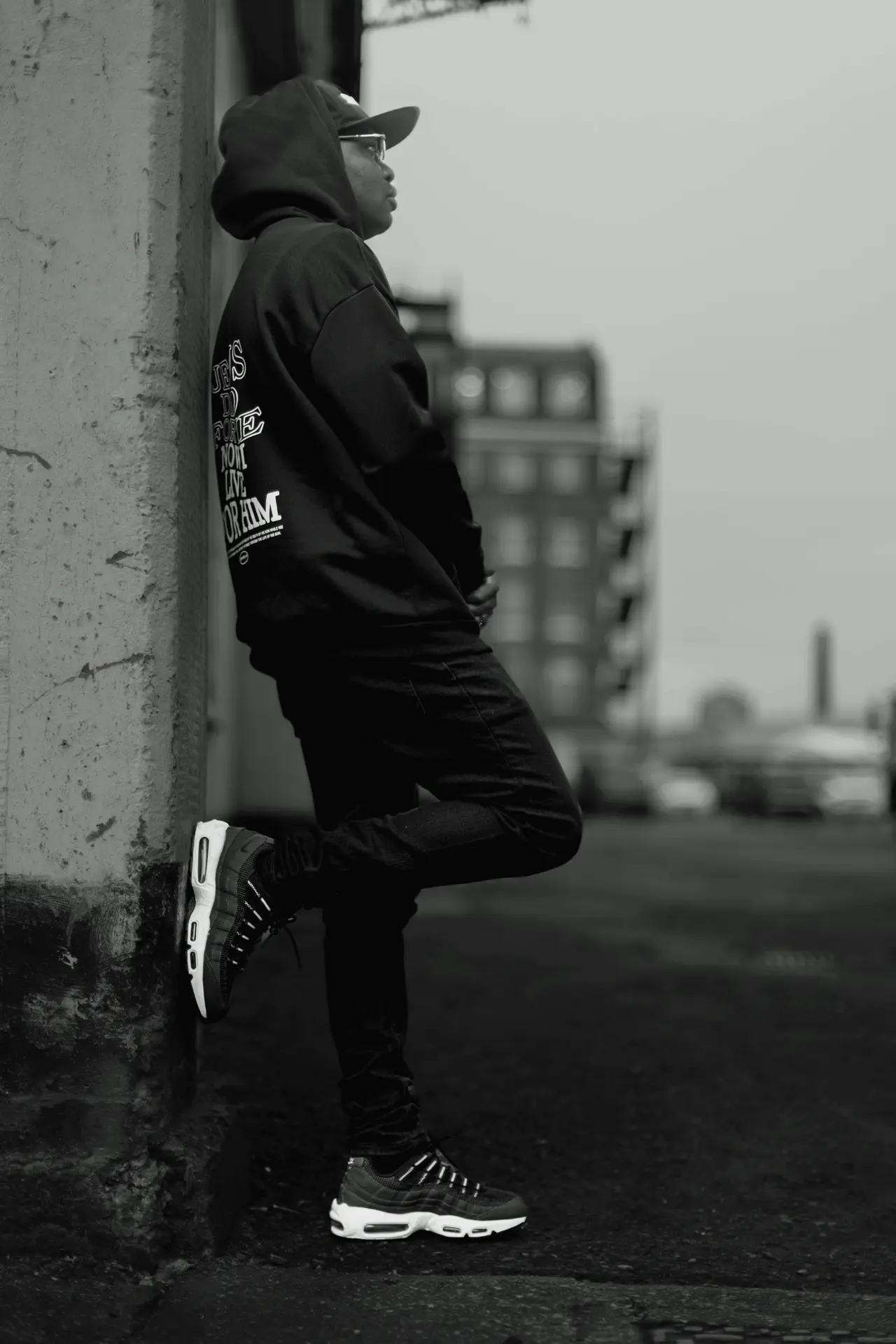 Tobi Tokz leaning on a wall in a street